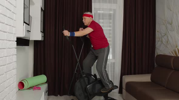 Senior Man in Sportswear Using Orbitrek in Living Room Doing Sport Training Cardio Exercises at Home