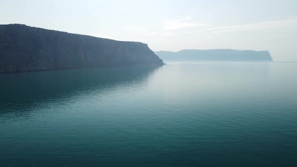 Aerial View From Above on Calm Azure Sea and Volcanic Rocky Shores