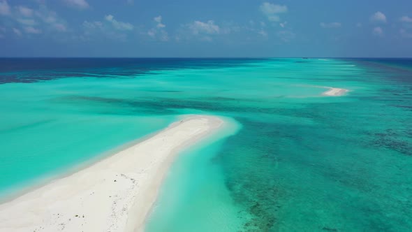 Wide drone island view of a sandy white paradise beach and turquoise sea background in 4K