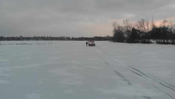 Guy running away from a truck on snow