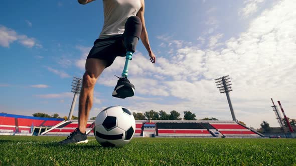 Football Field and a Man with a Prosthetic Leg Playing the Ball