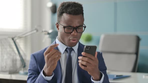 Portrait of African Man Reacting to Loss on Smartphone