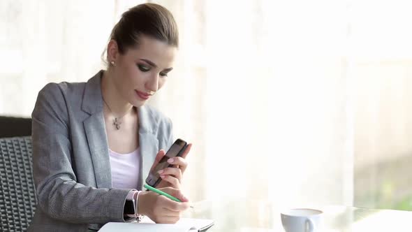 Hispanic Businesswoman Outside Office On Mobile Phone