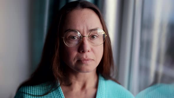 Portrait of Calm Pretty Middleaged Lady with Glasses in Apartment Near Window