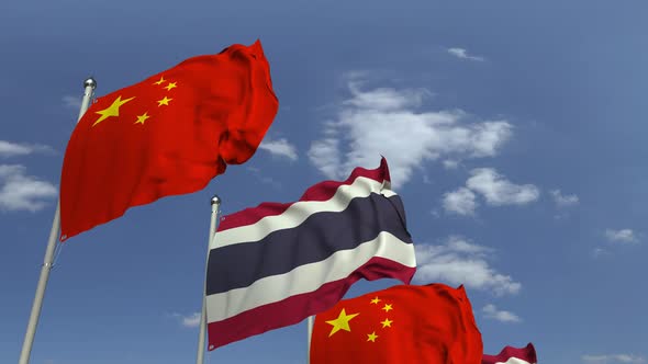 Flags of Thailand and China Against Blue Sky alt