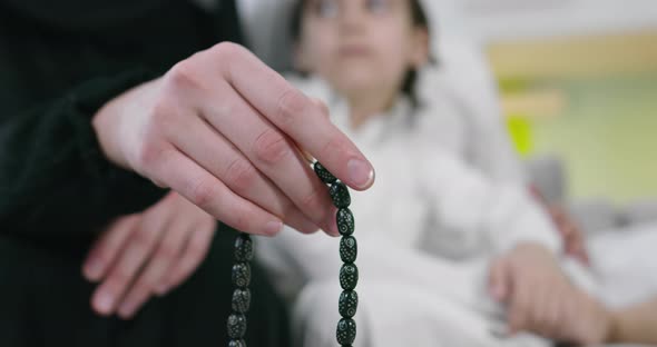 Muslim Woman Praying at Home with Kid in Background