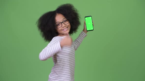 Young Cute African Girl with Afro Hair Showing Phone and Giving Thumbs Up