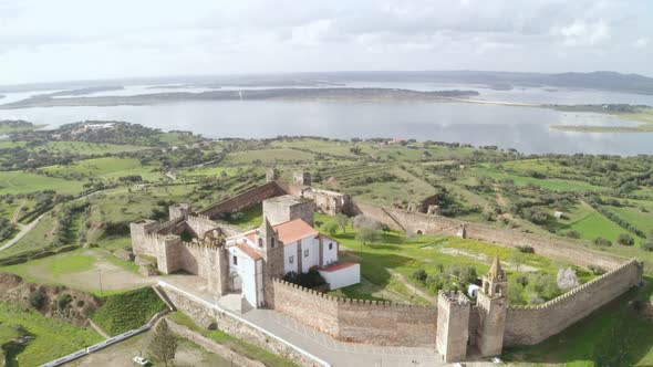 Aerial drone view of Mourao castle with alqueva dam lake behind