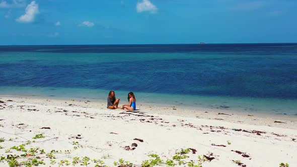 Women happy and smiling on idyllic coastline beach holiday by blue sea and white sandy background of