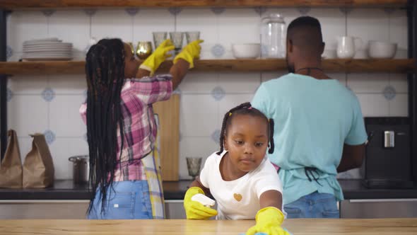 Happy Afroamerican Family Doing Cleaning at Kitchen Together