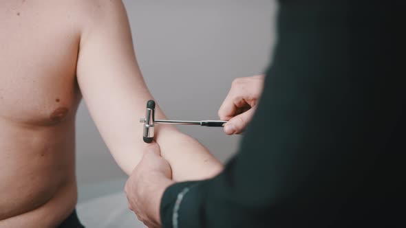 The Neurologist Checks the Reflex of the Patient's Hand