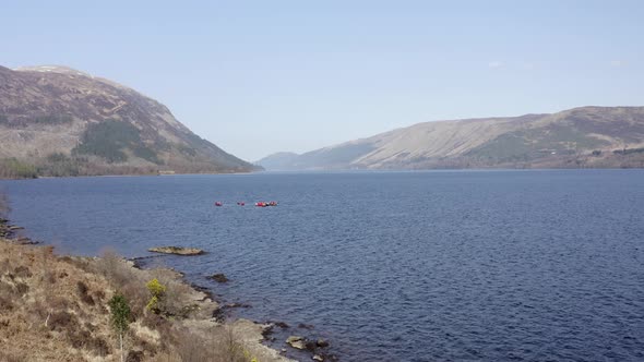 Canoeists in a Lake Surrounded by Forests and Mountains