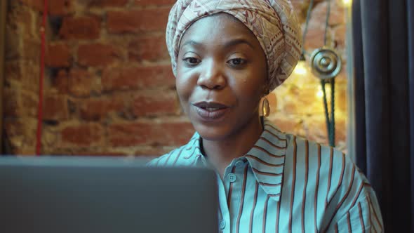 Black Woman Chatting on Video Call on Laptop in Cafe