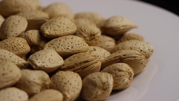 Cinematic, rotating shot of almonds on a white surface 