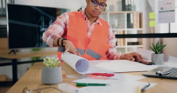 Male Engineer in Vest and Helmet Browsing Paper Project of Future Building