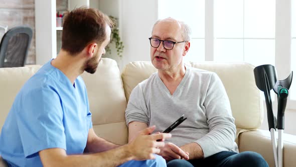 Caucasian Male Nurse Talking with a Nursing Home Patient About His Health