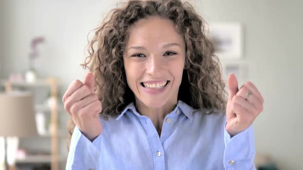 Curly Hair Woman Celebrating Success Gesture in Office