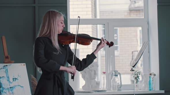 Young Blonde Woman Teacher Playing Violin in the Class