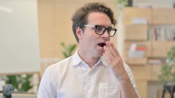 Portrait of Sleepy Young Man Yawning