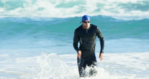 Male surfer running in the beach