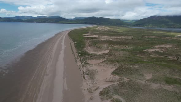 Dramatic Remote deserted Inch beach and sand dunes Dingle peninsula Ireland drone aerial view