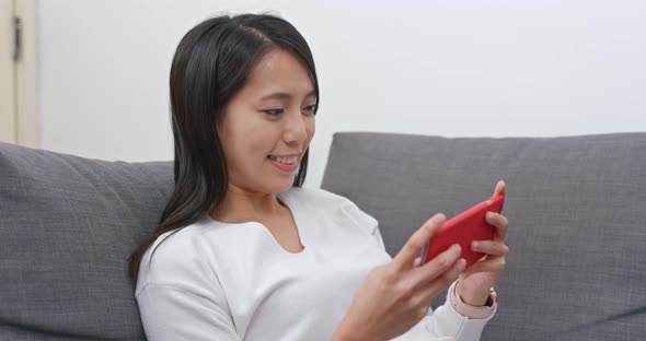 Woman play on cellphone at home