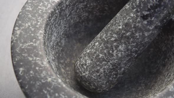 Close-up of Rose-red Peppercorns Falling Into the Grey Stone Mortar