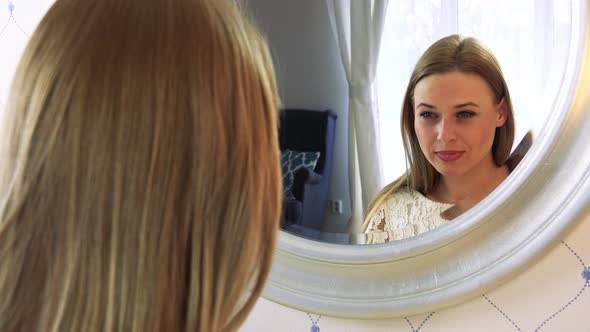 A Young Attractive Woman Makes Herself Up in Front of a Mirror
