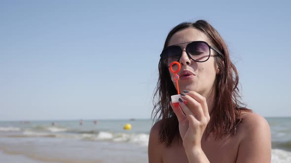 Female on ocean beach   blowing soap bubbles  slow-mo 1920X1080 HD video - Happy and beautiful young
