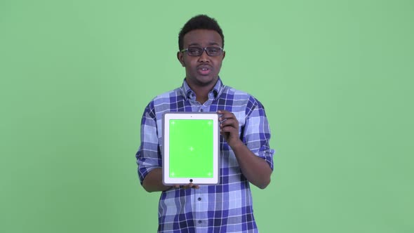 Happy Young African Hipster Man Talking While Showing Digital Tablet