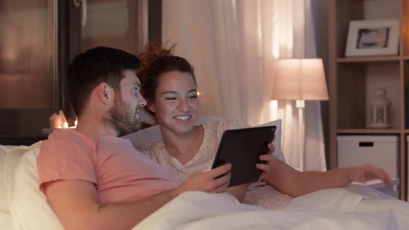 Happy Couple Using Tablet Computer in Bed at Night 25