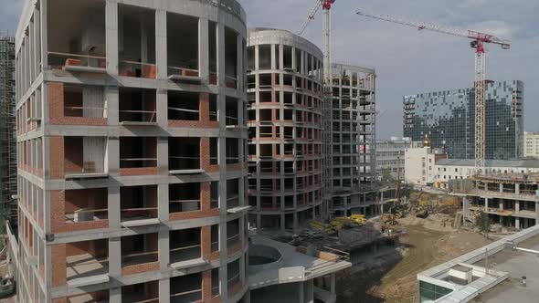 Aerial shot of construction of high-rise apartment buildings and cranes in city 01