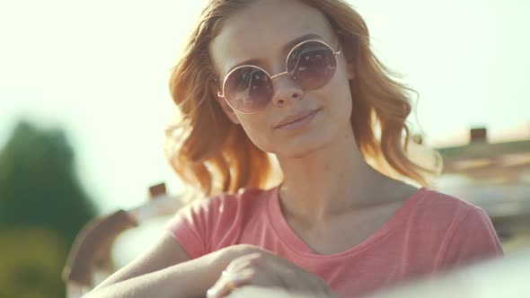 Beautiful Girl In Sunglasses Enjoying Summer Sun. Happy Smiling Woman Having Fun On Wind 