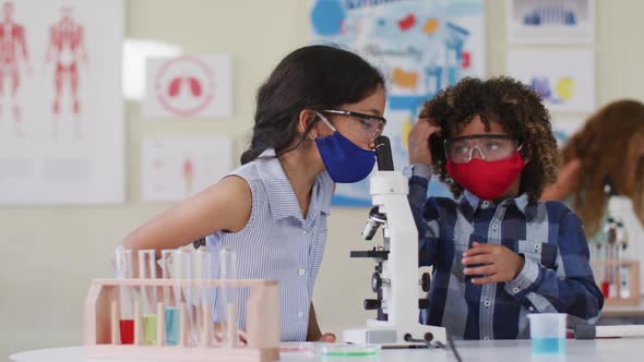 Boy and Girl wearing face mask and protective glasses at laboratory