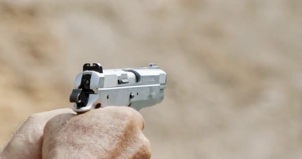 Pistol shooting bullets in slow motion footage. Hand guns in firing range