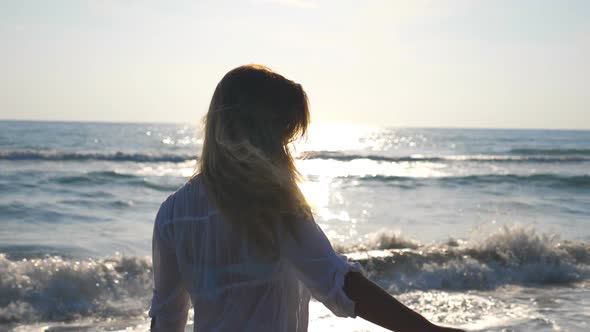 Young Woman in Bikini and Shirt Walking and Spinning on Sea Beach Sea. Beautiful Girl Touching Her