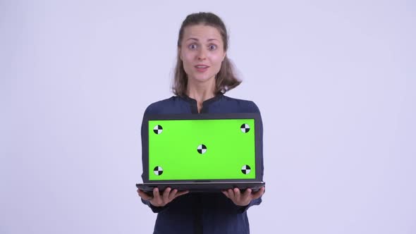 Happy Young Beautiful Businesswoman Showing Laptop and Looking Surprised