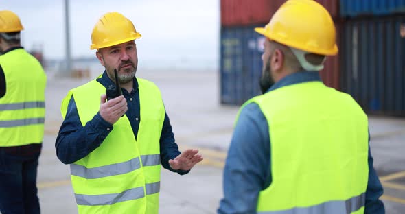 Engineer men controlling shipping containers inside industrial port