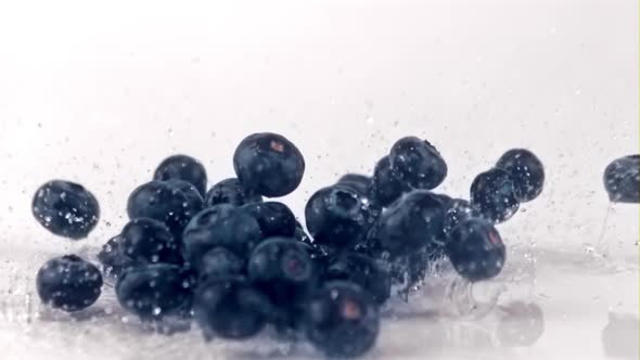 The Super Slow Motion of the Blueberries Falls on the Table with Splashes of Water