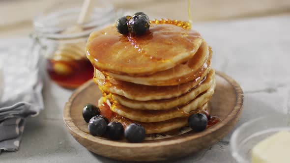 Video of pancakes on plate seen from above on wooden background