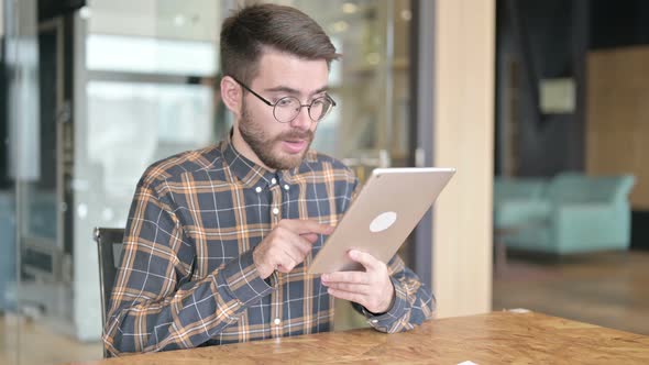 Hardworking Young Designer Having Success on Tablet in Office