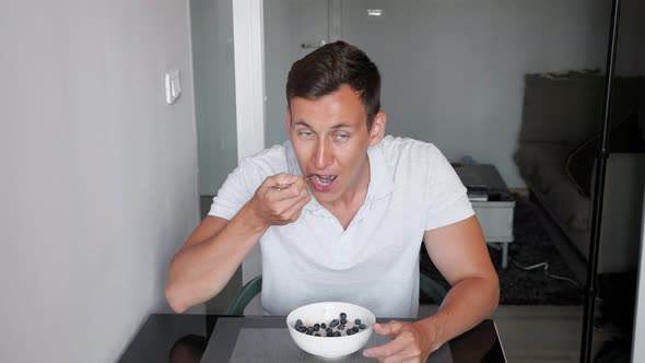 Sporty Guy in White Tshirt Eats Delicious Porridge Cereals