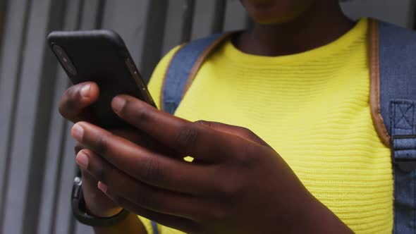 African american woman using smartphone in street