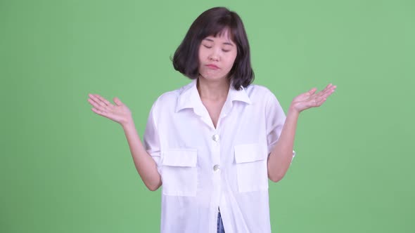 Confused Asian Businesswoman Shrugging Shoulders