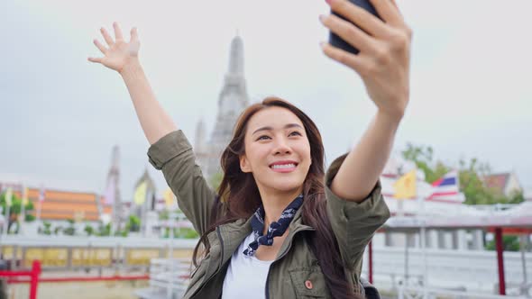 Asian woman backpacker use camera selfie and taking picture in city.