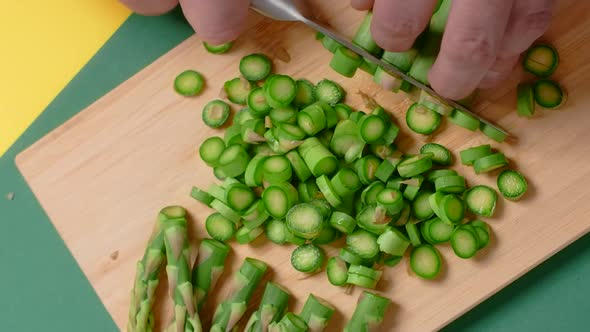 Vertical Flat Lay Video the Cook Cuts Raw Asparagus on the Wooden Board