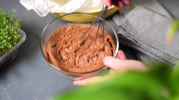 Stirring dough and cocoa powder with whisk