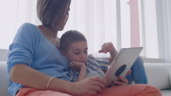 Mother and Son Playing with Digital Tablet at Home