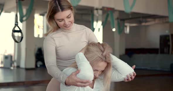 Happy Trainer Helping Pregnant Woman Doing Stretching Exercises