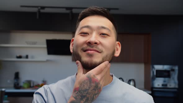 Happy Hipster Asian Man Checking Beard After Shaving